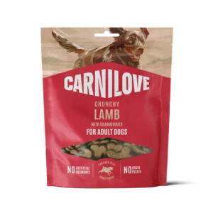 Carnilove Crunchy Lamb dog treats packaging with a small window showing the treats; for adult dogs, cranberry-flavored. Backed by a dog illustration on the bag.
