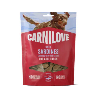 Carnilove Soft Sardines dog treats for adult dogs in a red bag with a dog on top; window showing treats and text about no artificial colorants and no grain or potato.