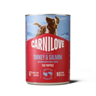 Can of Carnilove puppy dog food—turkey and salmon flavor, no grain, enriched with forest fruits; features a dog on the blue label.